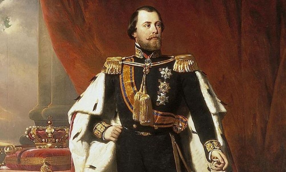 Een man in formele kledij met medailles en versieringen staat voor een rood gordijn. Op een tafel links van hem zijn een kroon en andere versieringen te zien, waaronder een pijl die bij de handboogsport wordt gebruikt.